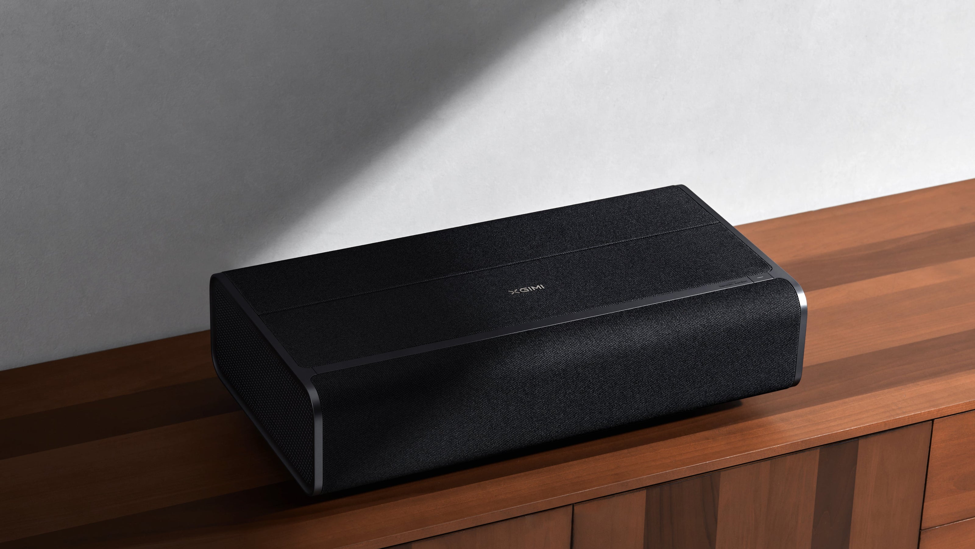 Black electronic device on a wooden surface with a neutral background